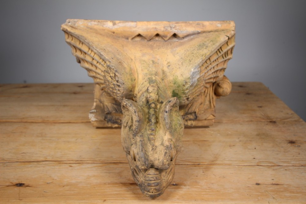 A nineteenth-century weathered buff terracotta gargoyle corbel featuring a winged beast with open jaws. View VI