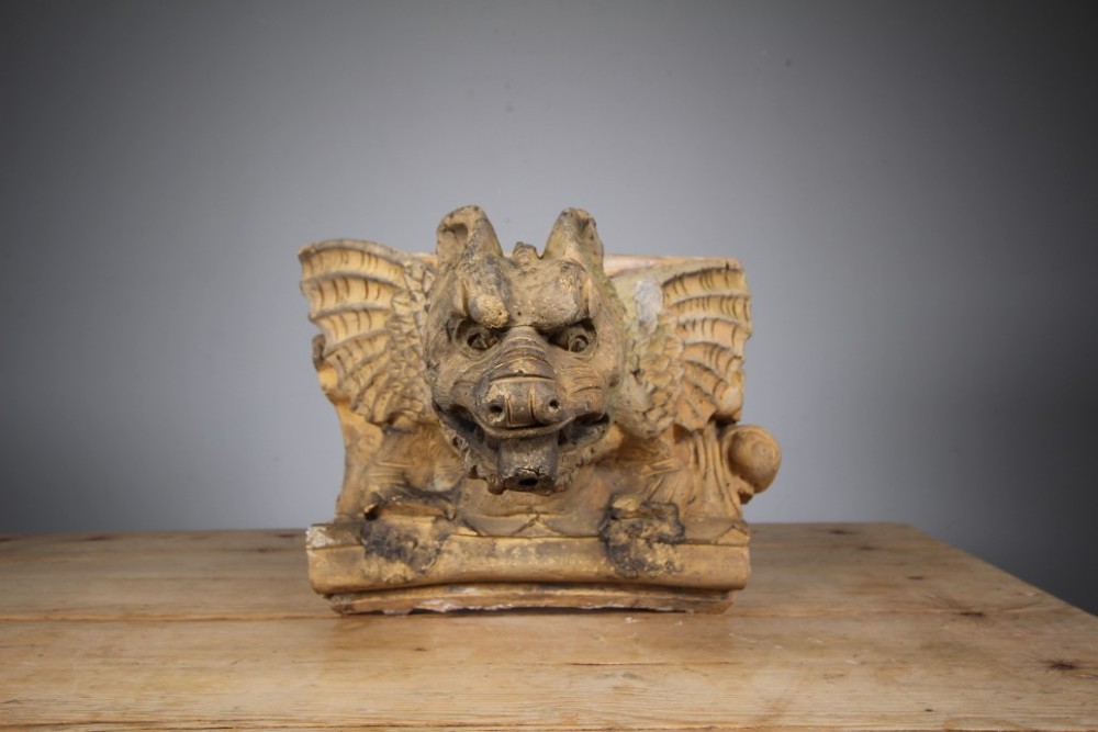 A nineteenth-century weathered buff terracotta gargoyle corbel featuring a winged beast with open jaws. View VII