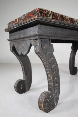 An early nineteenth-century black painted pine window seat featuring carved scroll legs decorated with repeating motifs and an upholstered geometric pad. View III