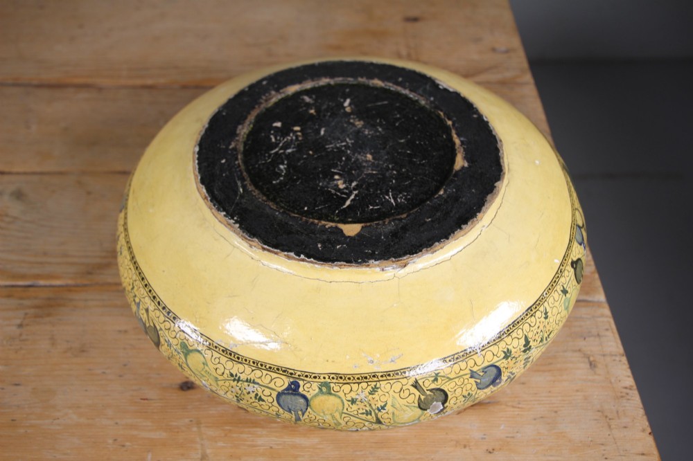A large rounded Kashmiri papier-mache bowl painted in yellow with black foliage scrolls and multi-coloured birds. View II
