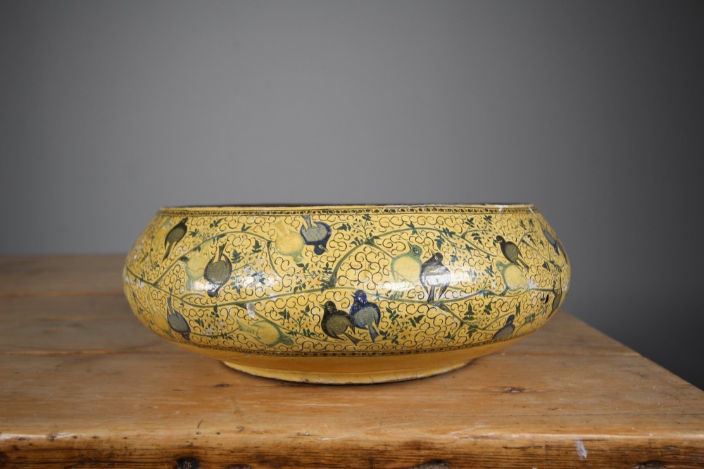 A large rounded Kashmiri papier-mache bowl painted in yellow with black foliage scrolls and multi-coloured birds. View III
