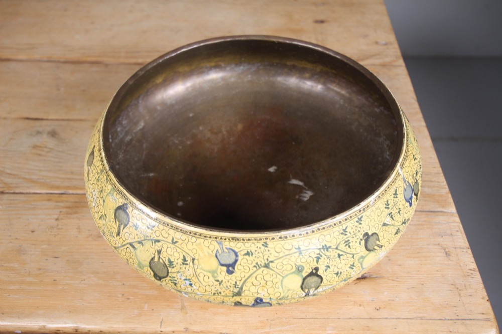 A large rounded Kashmiri papier-mache bowl painted in yellow with black foliage scrolls and multi-coloured birds. View V