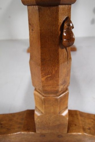 An English Arts and Crafts adzed oak refectory dining table featuring octagonal pedestal legs connected by a floor stretcher, displaying a carved mouse signature. View II