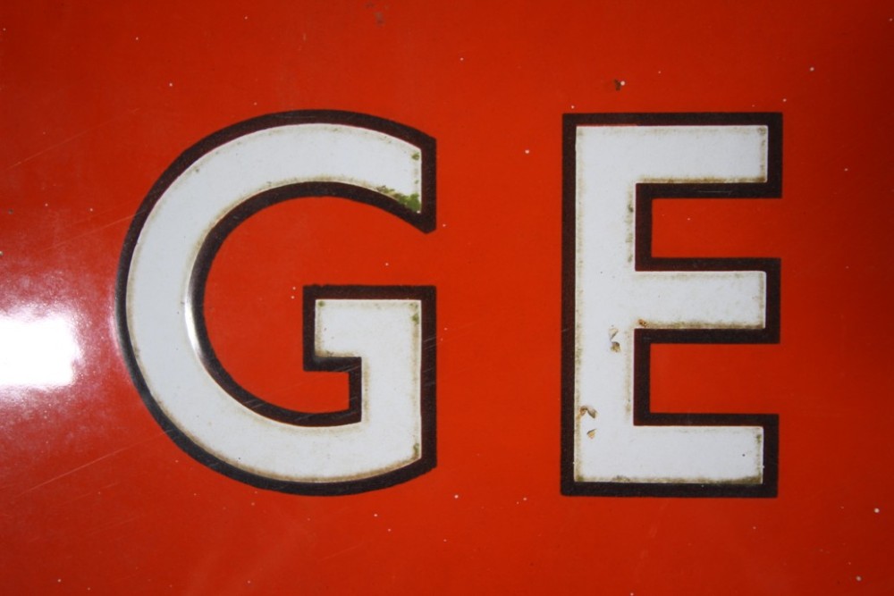A rectangular red vitreous enamel railway sign featuring the word GENTLEMEN in bold white capital letters with black outlines. View IV