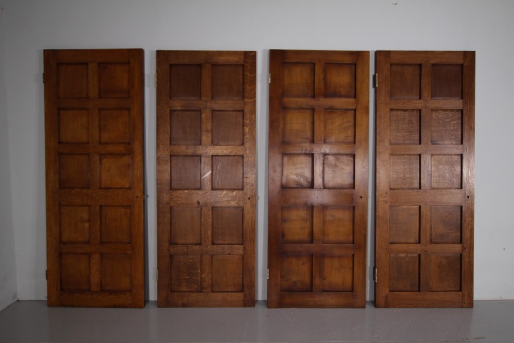 A solid oak interior door featuring ten raised panels, a hand-adzed textured finish, wrought iron latch hardware, and a carved mouse detail. View VII