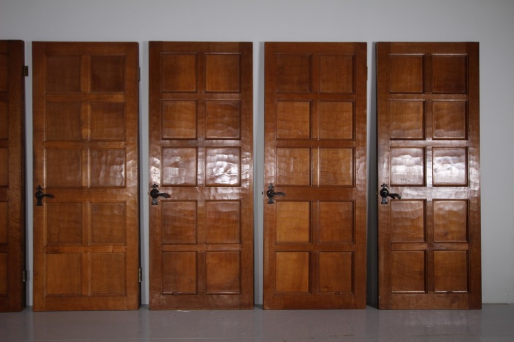 A solid oak interior door featuring ten raised panels, a hand-adzed textured finish, wrought iron latch hardware, and a carved mouse detail. View X
