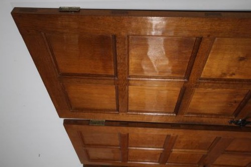A solid oak interior door featuring ten raised panels, a hand-adzed textured finish, wrought iron latch hardware, and a carved mouse detail. View IV