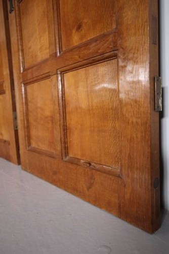 A solid oak interior door featuring ten raised panels, a hand-adzed textured finish, wrought iron latch hardware, and a carved mouse detail. View V