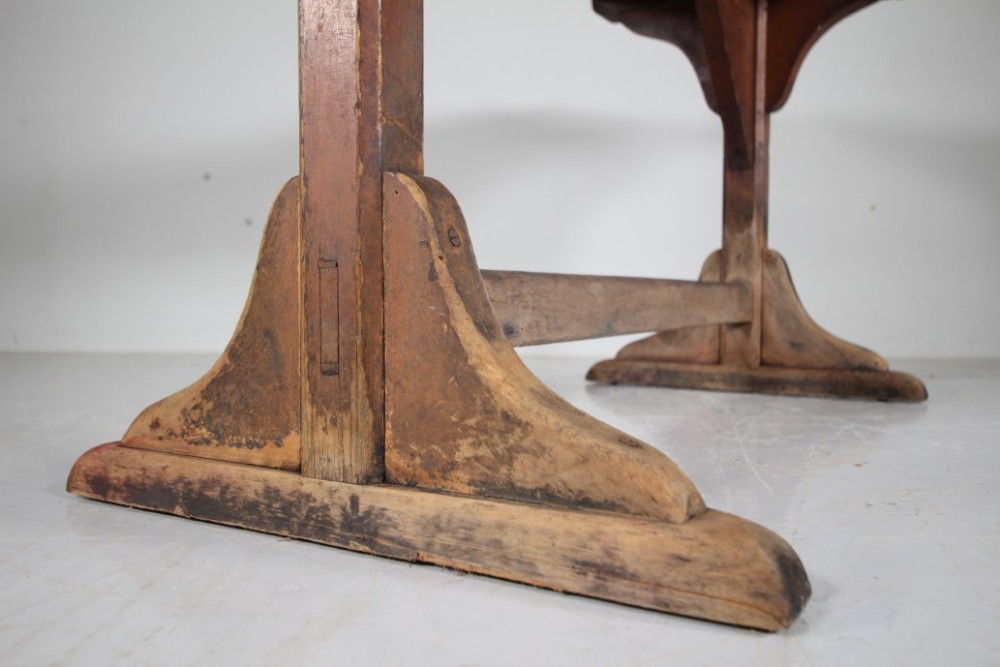 An English nineteenth-century trestle tavern dining table featuring a scrubbed natural timber top and a distressed red-painted base with a stretcher. View V