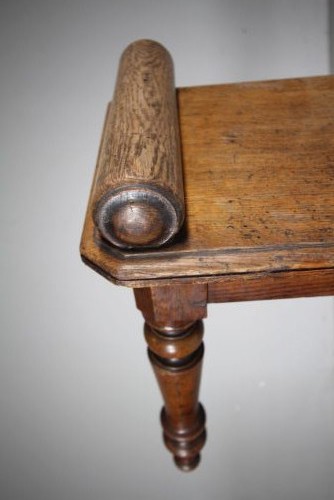 A 19th-century English oak window seat featuring cylindrical bolster armrests and four turned legs. View IV