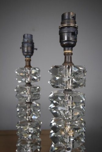 A pair of 1920s English cut glass table lamps featuring stacked faceted glass elements on round cut bases with dark metal lamp holders. View IV