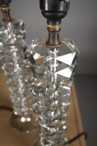A pair of 1920s English cut glass table lamps featuring stacked faceted glass elements on round cut bases with dark metal lamp holders. View VI
