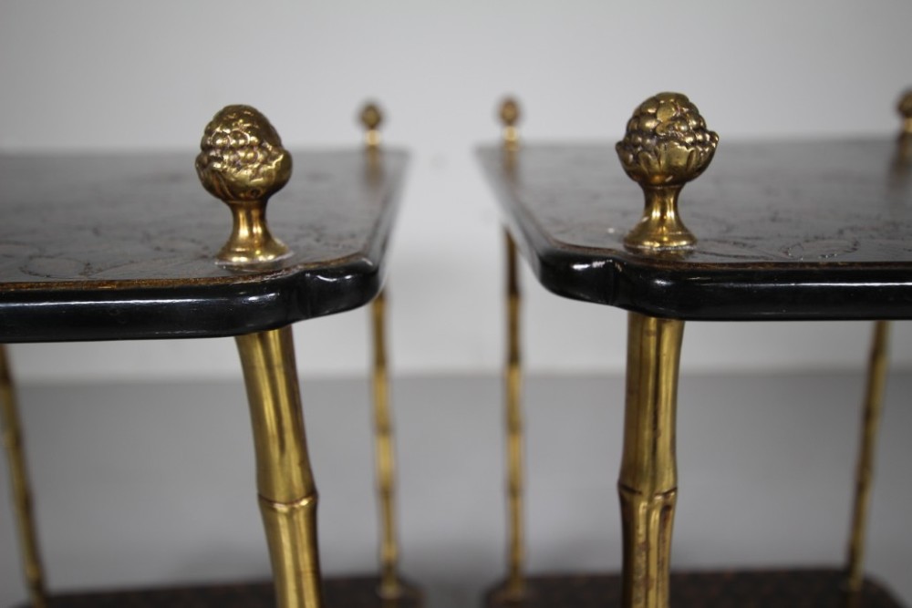 A pair of mid-century two-tier side tables with brass simulated bamboo legs and brown patterned lacquered surfaces topped with pinecone finials. View II