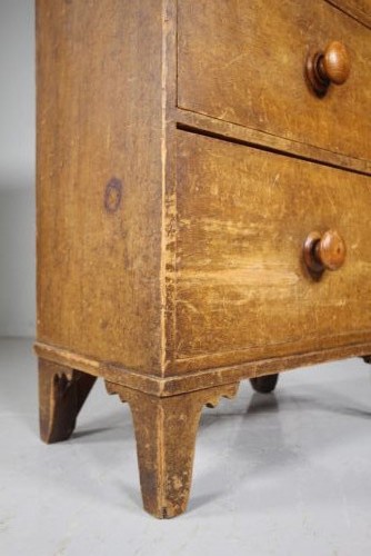 A Georgian painted pine chest of drawers featuring three drawers with wooden knobs and shaped cut-out feet. View V