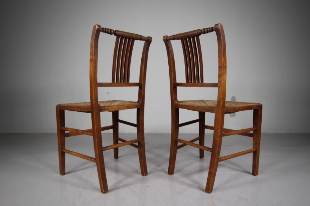A set of six early 19th-century elm country dining chairs featuring vertical slat backs, turned bobbin top rails, and woven rush seats. View VIII