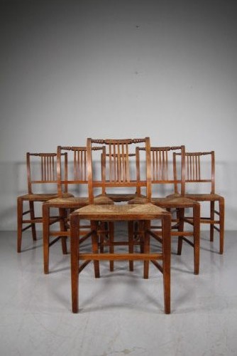 A set of six early 19th-century elm country dining chairs featuring vertical slat backs, turned bobbin top rails, and woven rush seats. View II