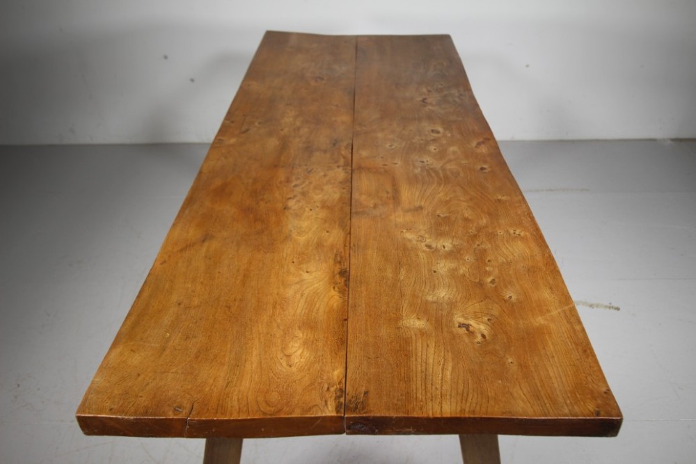 An early 19th century primitive dining table crafted from timber featuring a thick slab top and splayed legs. View III