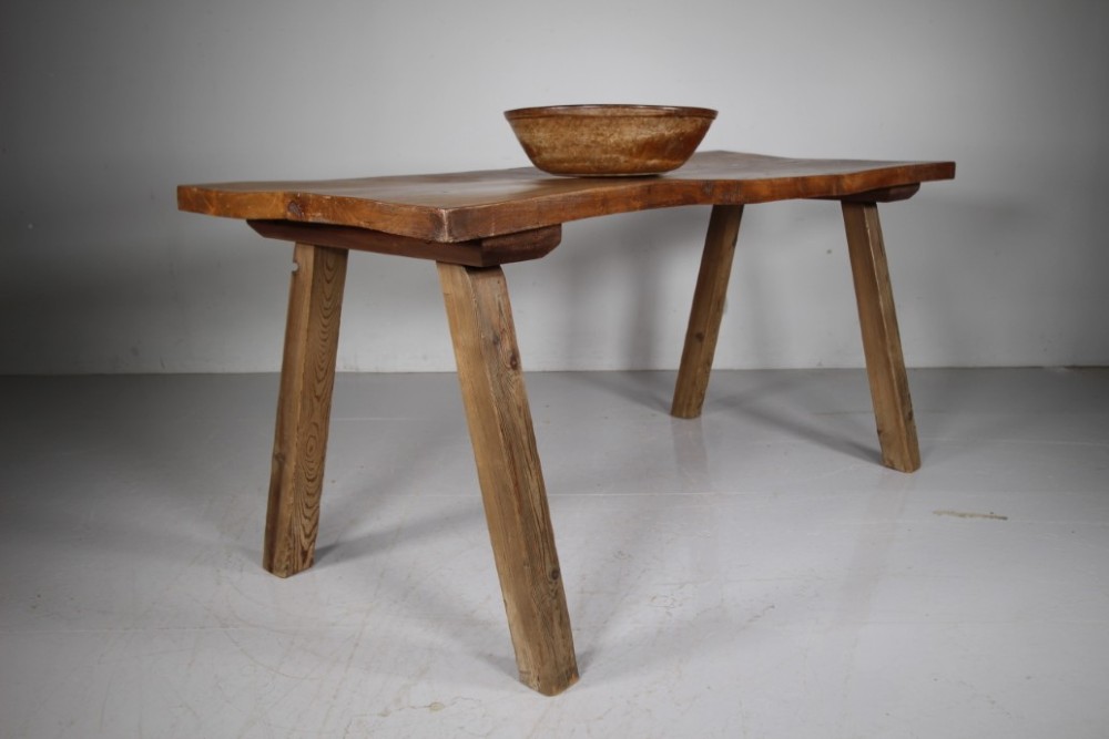 An early 19th century primitive dining table crafted from timber featuring a thick slab top and splayed legs. View VI