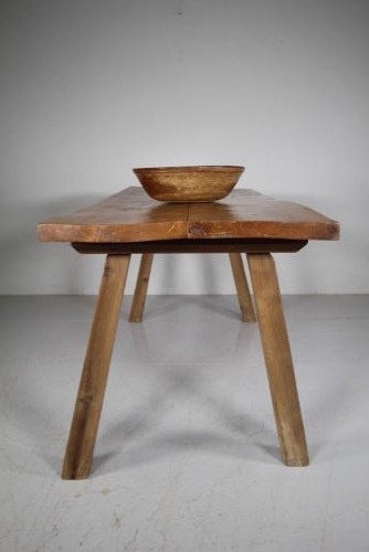 An early 19th century primitive dining table crafted from timber featuring a thick slab top and splayed legs. View II