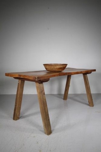 An early 19th century primitive dining table crafted from timber featuring a thick slab top and splayed legs. View V