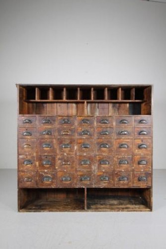 A large 19th-century pine bank of drawers featuring thirty-five small drawers with metal cup handles, top pigeonhole compartments, open bottom shelving, and a dark painted outer frame. View IV
