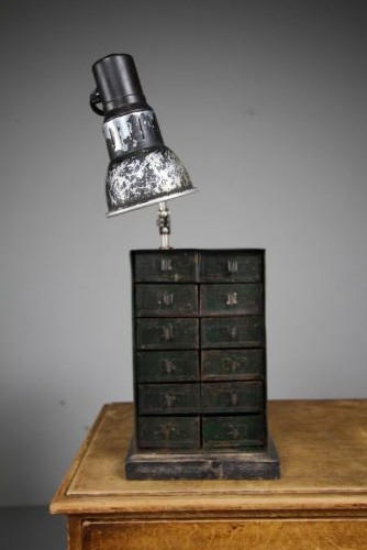 A dark green painted metal chest of twelve small drawers featuring an attached articulated industrial task lamp with a distressed shade. View V