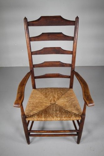 A nineteenth-century dark ash ladderback armchair featuring five horizontal back slats, sloped armrests, turned front legs, and a hand-woven rush seat. View IV