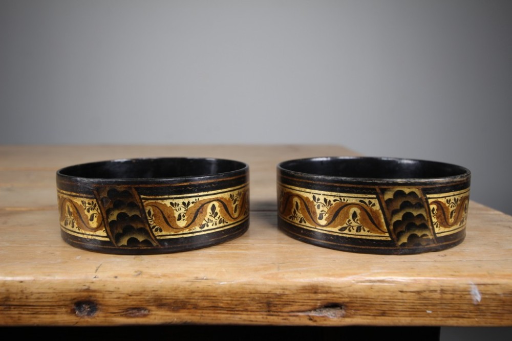 A pair of circular Regency black japanned wine coasters decorated with gilded leaf motifs and scrolling foliage. View II