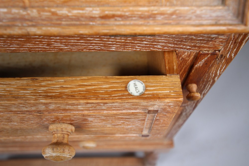 A 1920s light oak writing bureau featuring a slanted fall-front lid, two lower drawers with wooden knobs, and turned legs with a box stretcher. View II