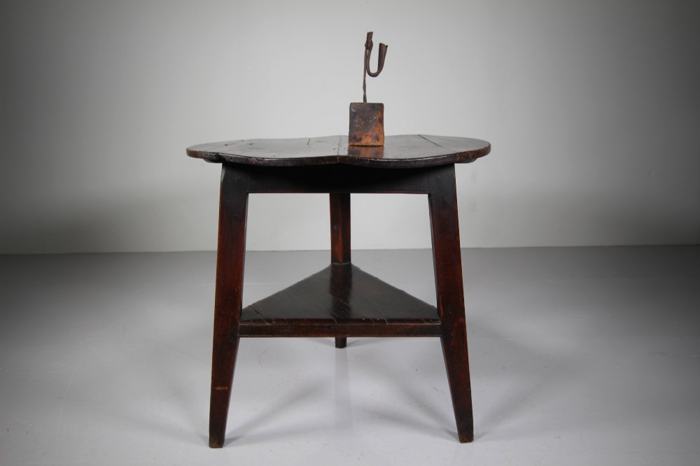 An 18th-century English oak cricket table featuring a circular top, three tapered legs, and a lower triangular shelf. View II