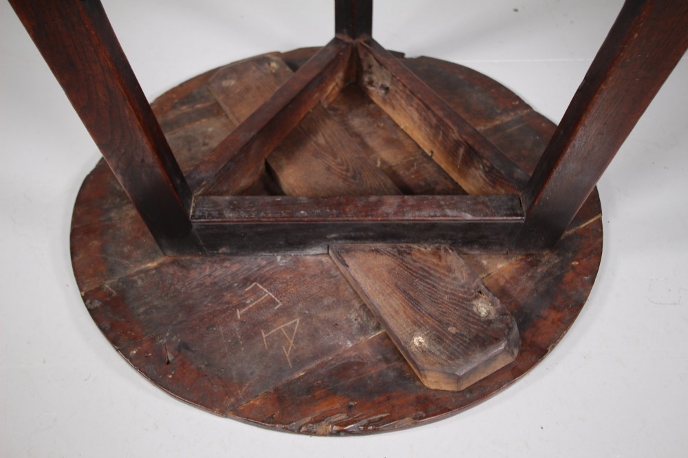 An 18th-century English oak cricket table featuring a circular top, three tapered legs, and a lower triangular shelf. View IV