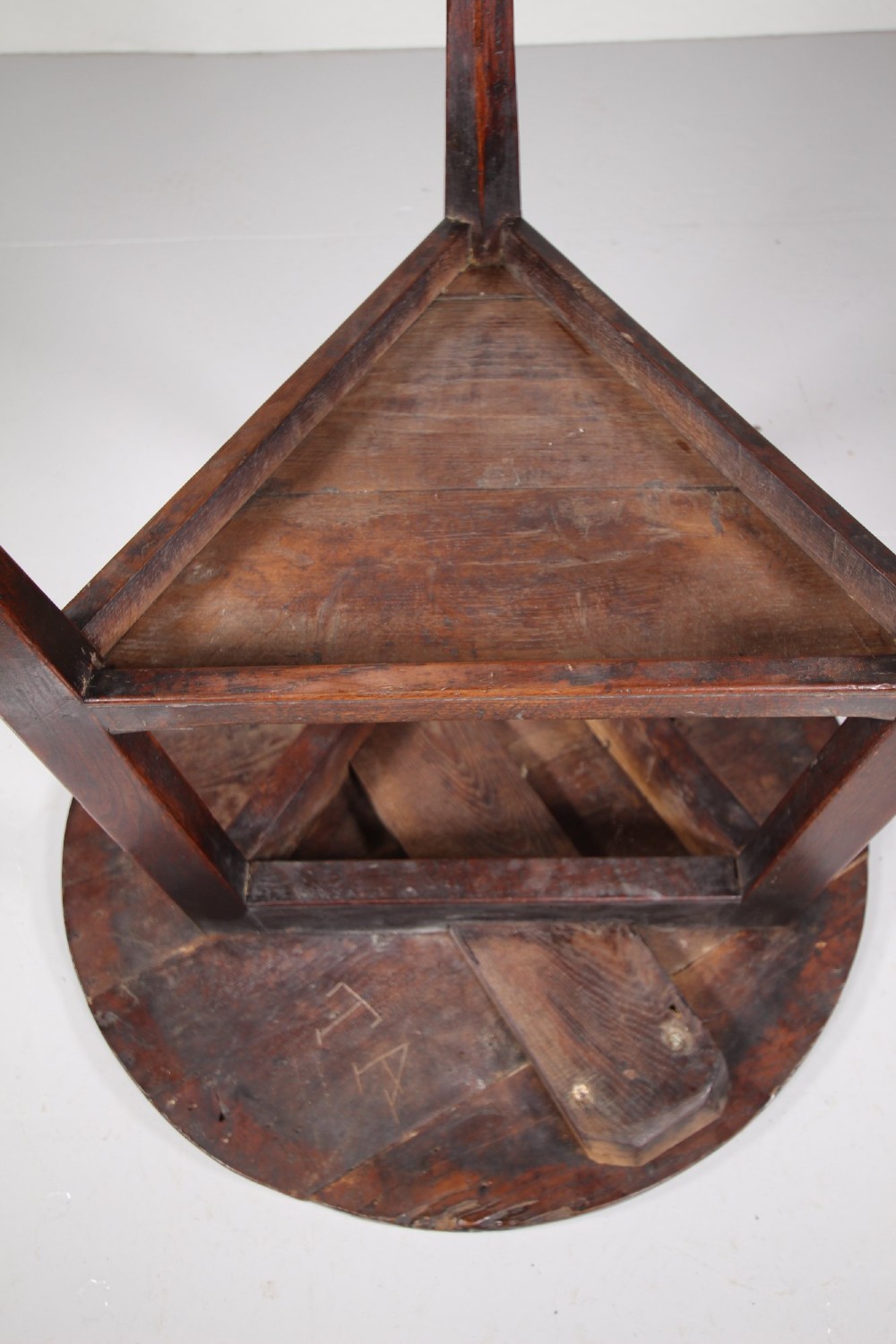 An 18th-century English oak cricket table featuring a circular top, three tapered legs, and a lower triangular shelf. View V