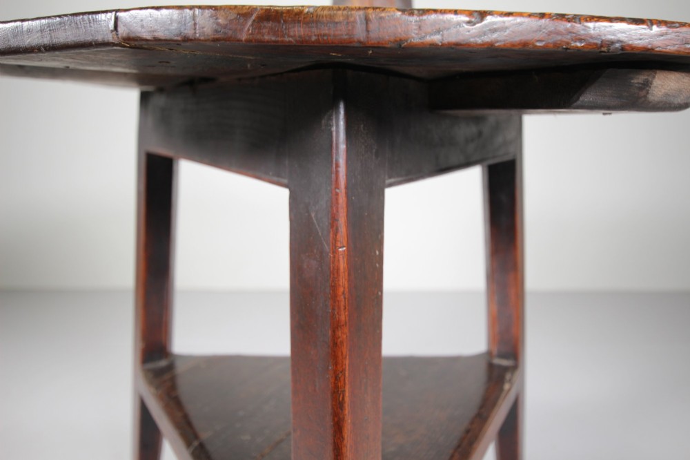 An 18th-century English oak cricket table featuring a circular top, three tapered legs, and a lower triangular shelf. View VII