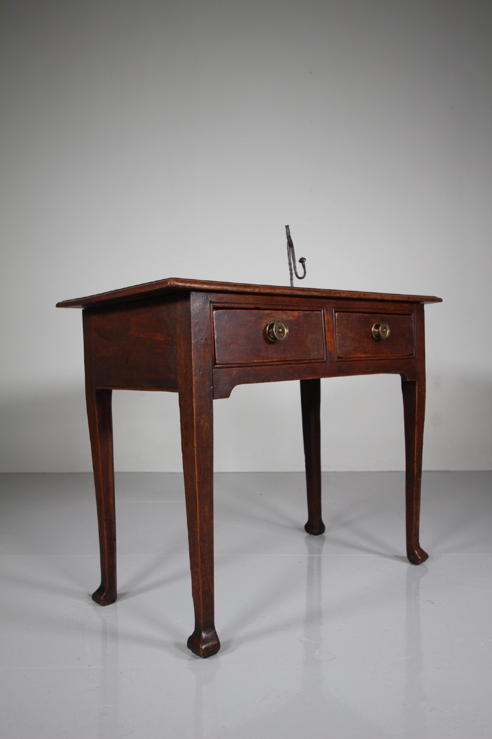 An 18th-century English side table crafted from warm brown elm and fruitwood featuring two drawers with circular brass drop handles and tapered legs. View III