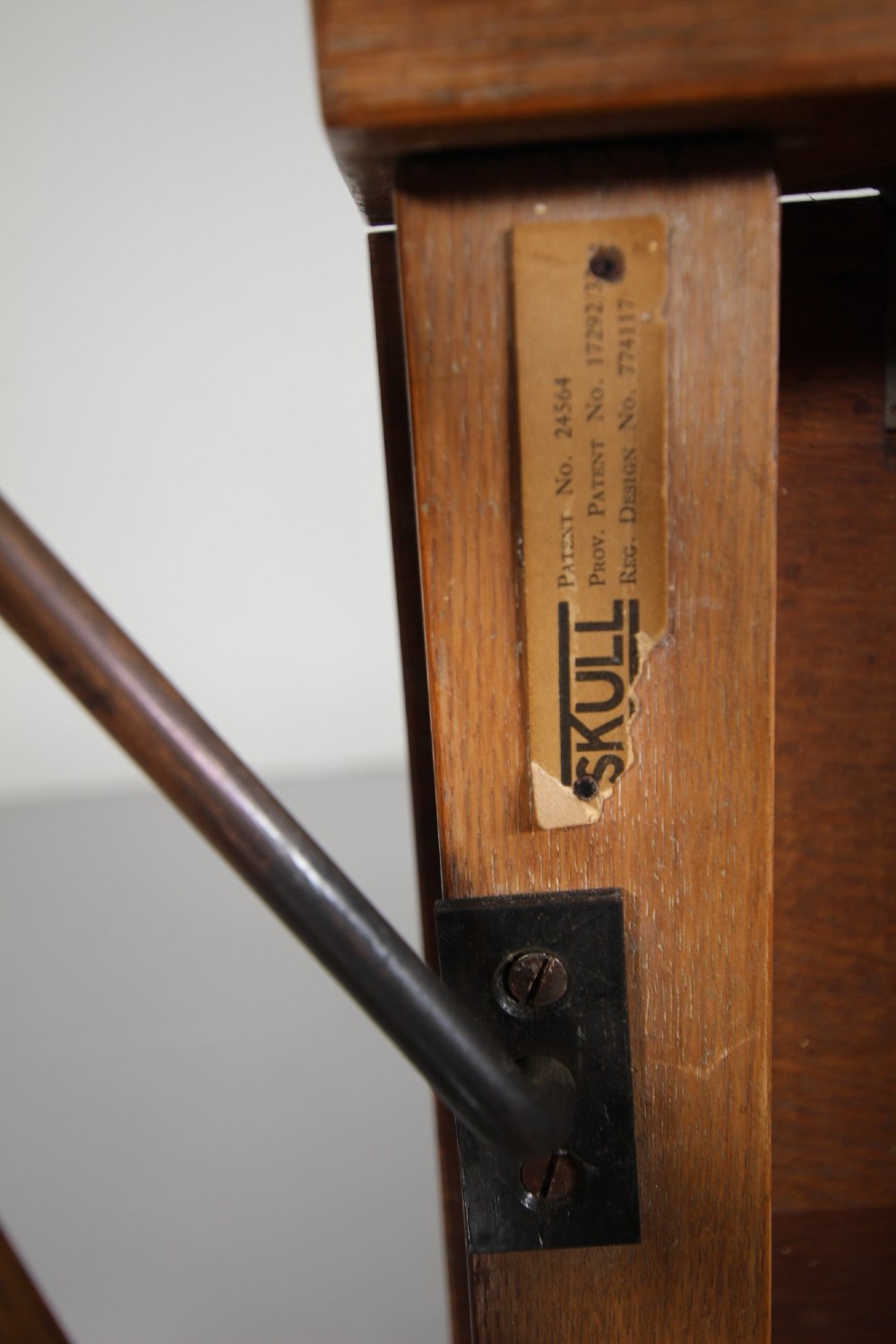 A 1930s solid oak reclining armchair frame featuring integrated side bookshelves, an adjustable slatted backrest, and a folding drop-leaf side table. View VI
