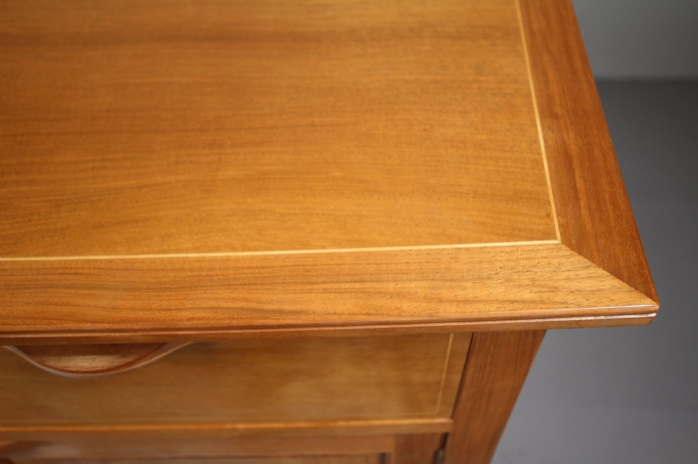 A pale walnut sideboard featuring four drawers above four cabinet doors with panelled detailing and tapered legs. View XIII