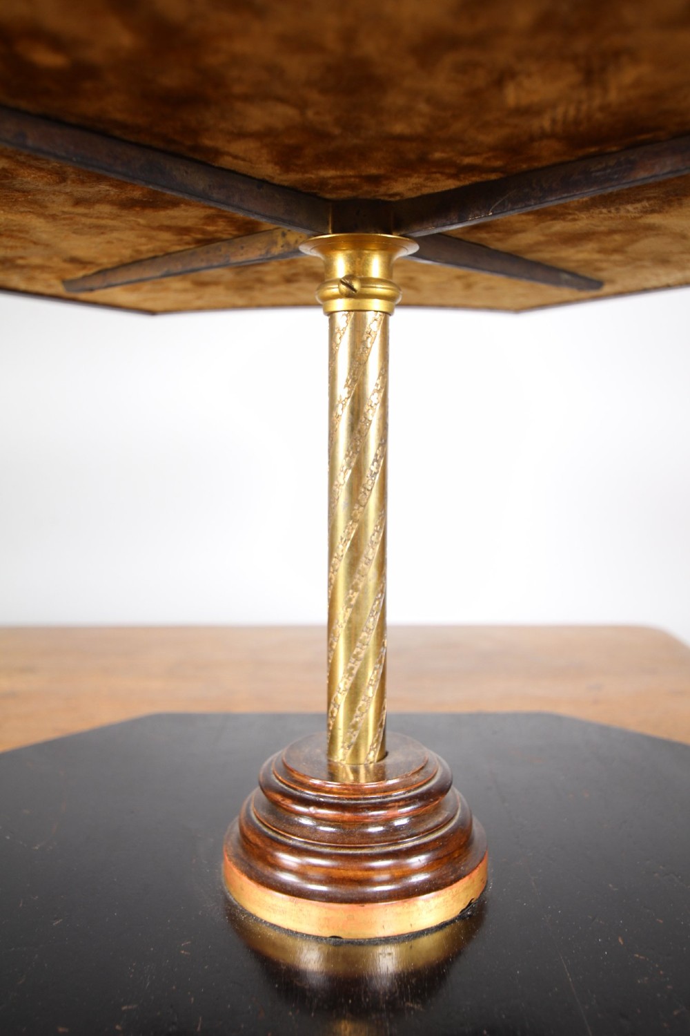 A nineteenth-century Victorian three-tiered shop display stand featuring a turned brass central column, shaped ebonised shelves, and a heavy black octagonal base. View III
