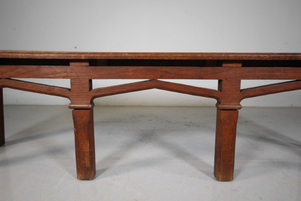 A long antique oak hall bench with a woven lattice top surface and pointed arch under-framing supported by square legs. View V