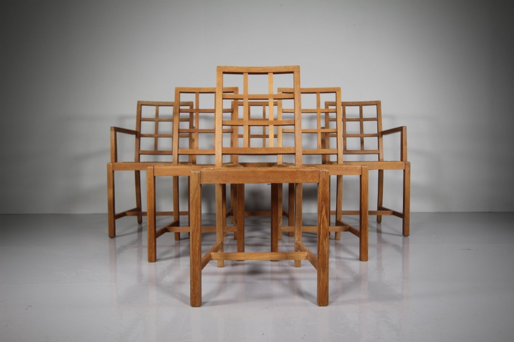 A set of six light oak dining chairs featuring geometric lattice backrests and woven seats, including two carvers with armrests.