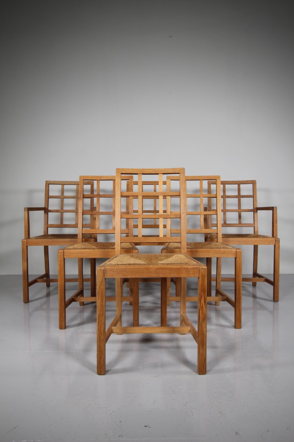 A set of six light oak dining chairs featuring geometric lattice backrests and woven seats, including two carvers with armrests. View VIII