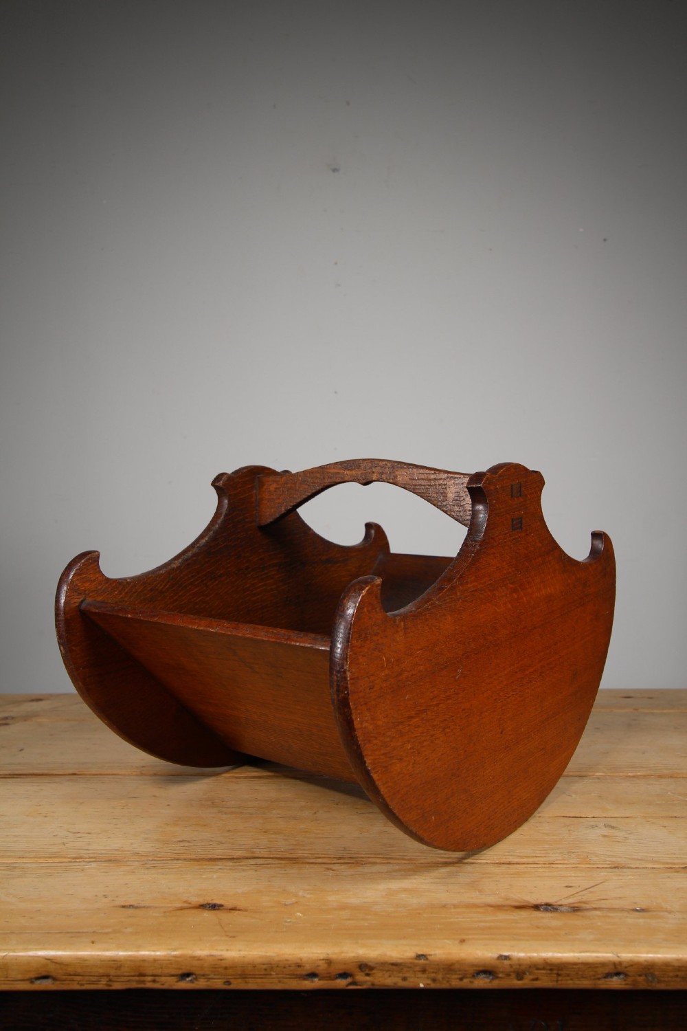 An Arts and Crafts solid oak book trug featuring a central carrying handle, curved side panels, and exposed joinery. View II