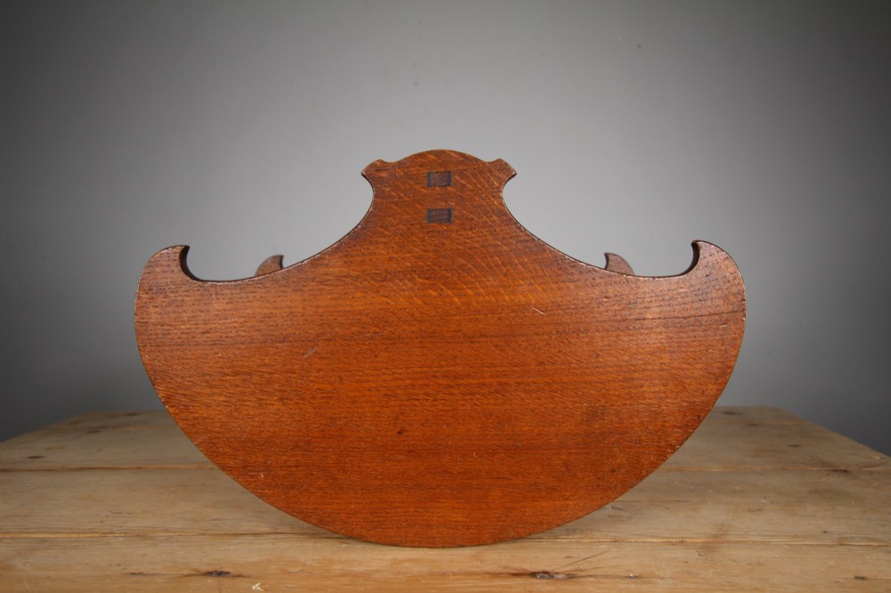 An Arts and Crafts solid oak book trug featuring a central carrying handle, curved side panels, and exposed joinery. View V