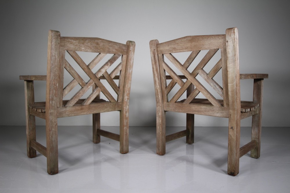 A set of four weathered teak garden armchairs with geometric Chinese Chippendale lattice backrests and square legs. View IV