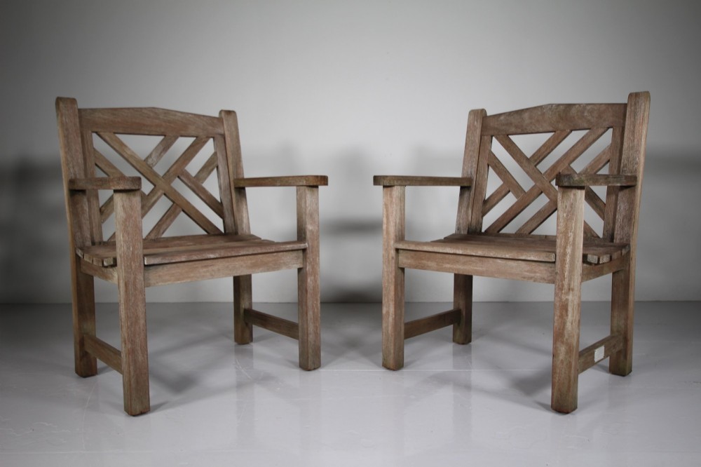 A set of four weathered teak garden armchairs with geometric Chinese Chippendale lattice backrests and square legs. View V