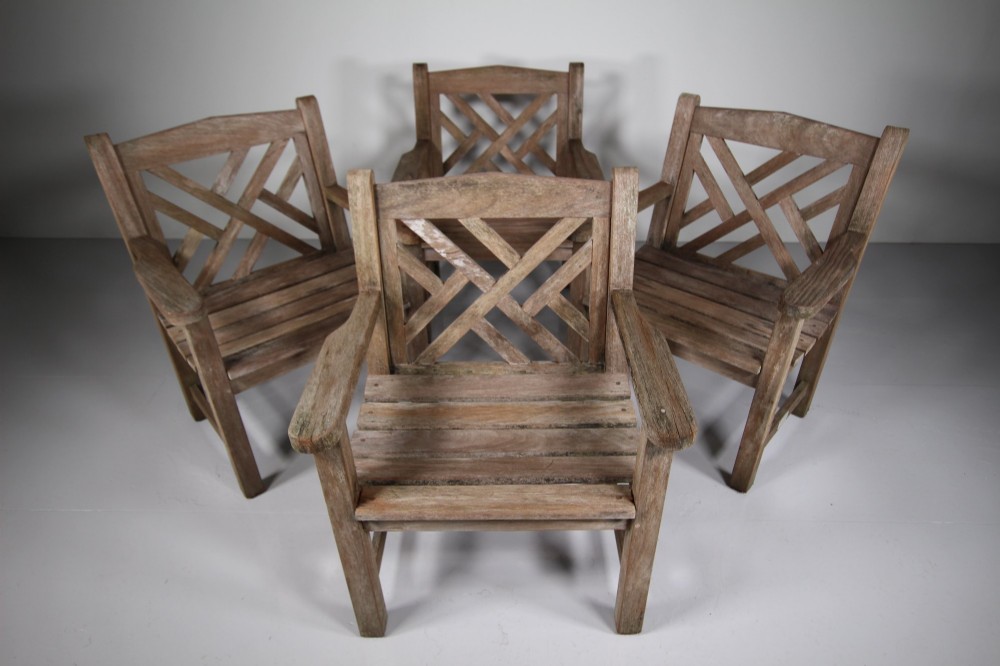 A set of four weathered teak garden armchairs with geometric Chinese Chippendale lattice backrests and square legs. View VII