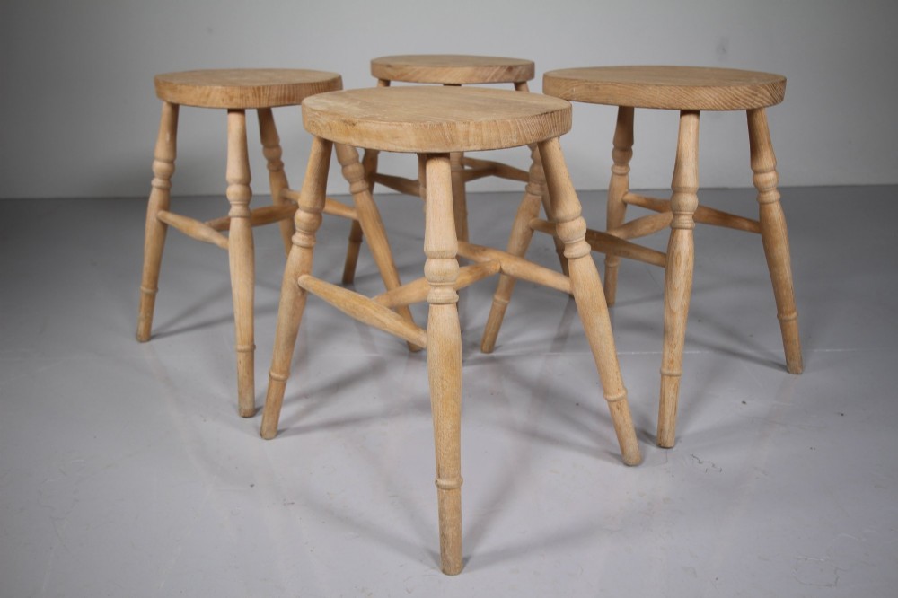 A set of four Edwardian natural wood dining stools featuring oval seats, turned legs, and lower stretchers. View II