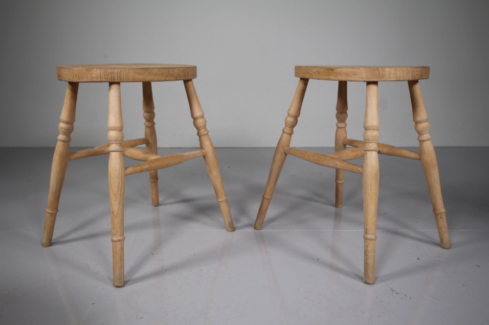 A set of four Edwardian natural wood dining stools featuring oval seats, turned legs, and lower stretchers. View IV