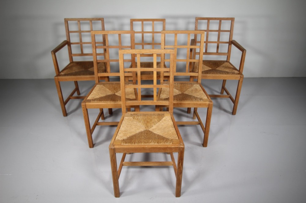 A set of six light oak 1920s dining chairs featuring geometric lattice backs, straight legs, and woven seats. View II