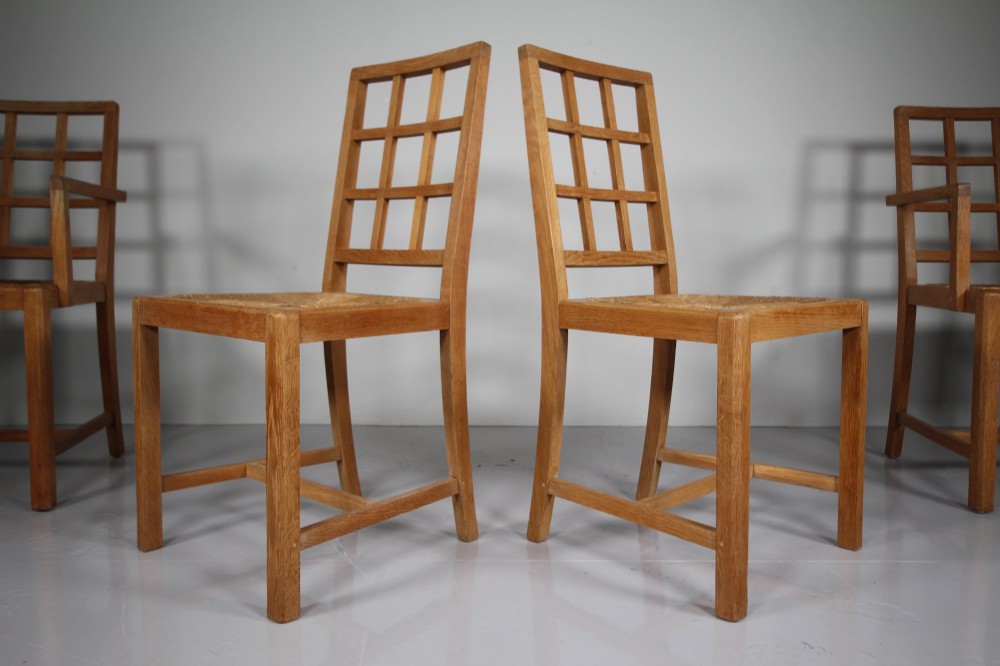A set of six light oak 1920s dining chairs featuring geometric lattice backs, straight legs, and woven seats. View VI
