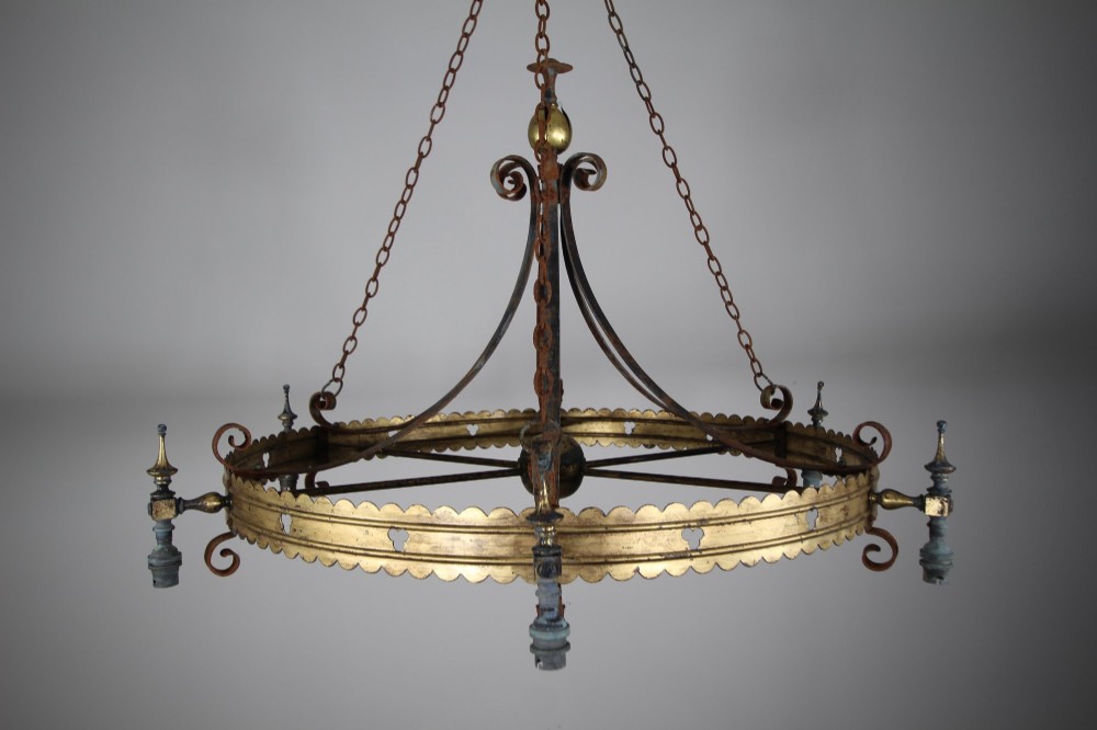 A 19th-century Gothic Revival brass and iron chandelier featuring a scalloped coronet band supported by suspension chains and curved lower scrollwork. View VII